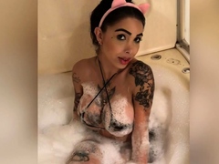 Tattooed brunette showing off her big boobs in the bathtub